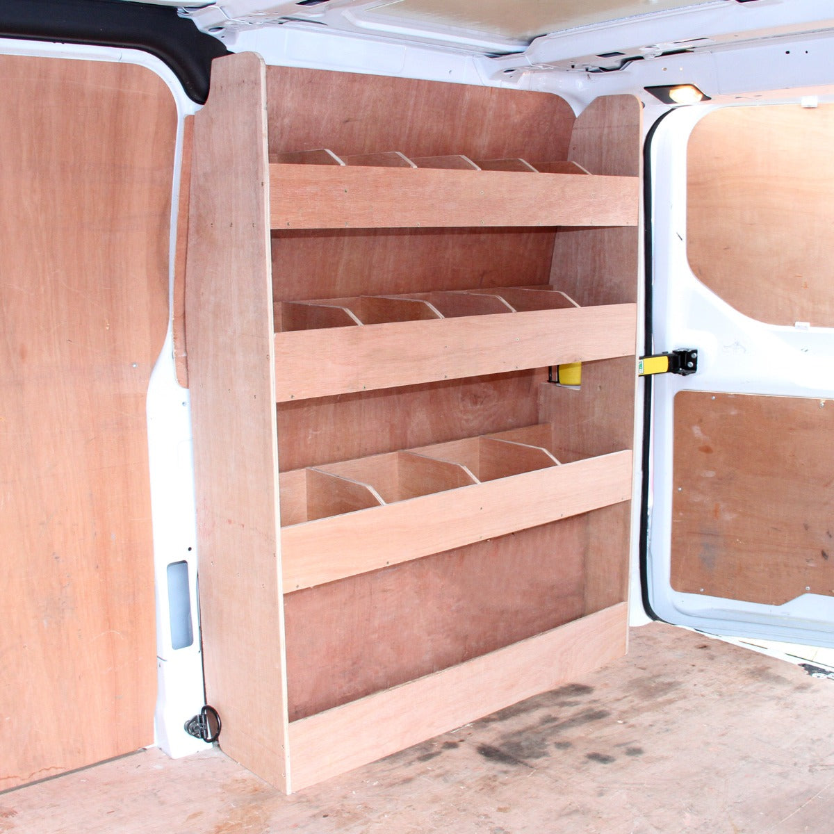 Scaffale in legno chiaro con cinque ripiani, progettato per furgoni Ford Transit, su sfondo di pannelli di legno scuro