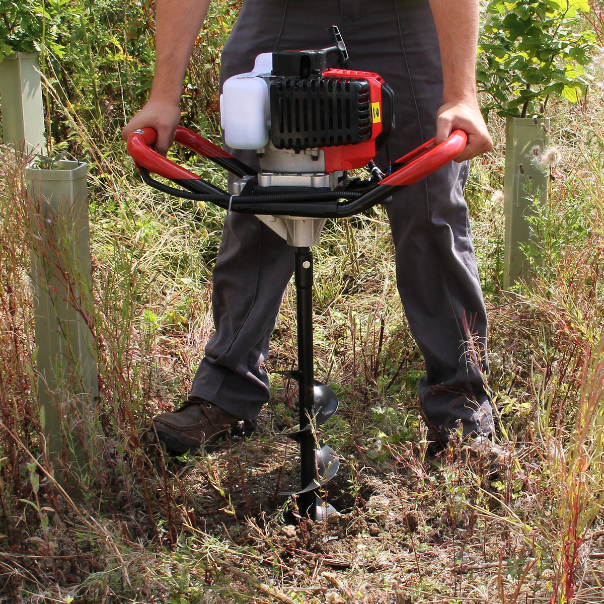 Trivella T-Mech per la terra con manico rosso, motore a 4 tempi, utilizzata per il montaggio di pali in un terreno erboso e irregolare