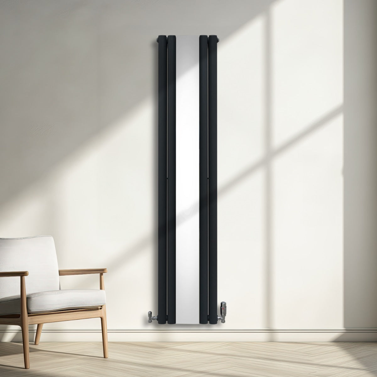 Radiatore a pannelli ovali grigio antracite, con finitura cromata a specchio, installato su parete luminosa, accanto a una sedia moderna