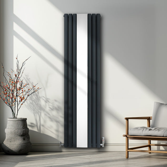 Radiatore a pannelli ovali grigio antracite con finitura cromata a specchio, installato in un ambiente moderno e luminoso