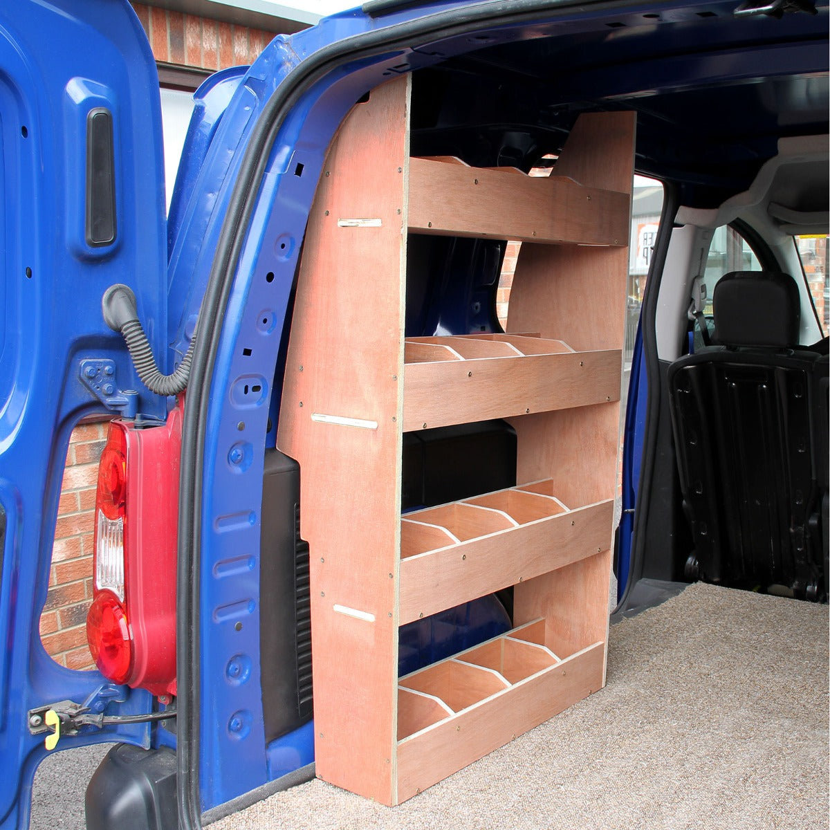 Scaffale in legno chiaro con tre ripiani, montato nel vano di un furgone Citroen Berlingo II, su fondo blu e tappeto grigio fumo