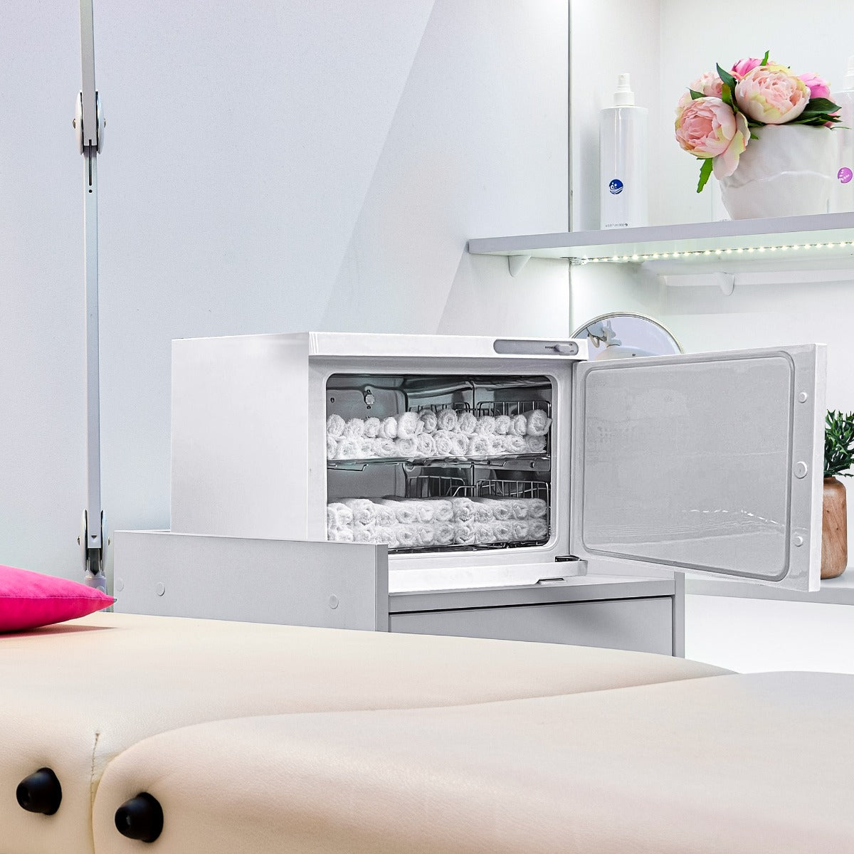 Scaldasalviette bianco elegante con porta trasparente, contenente asciugamani bianchi, posizionato su un mobile chiaro e moderno