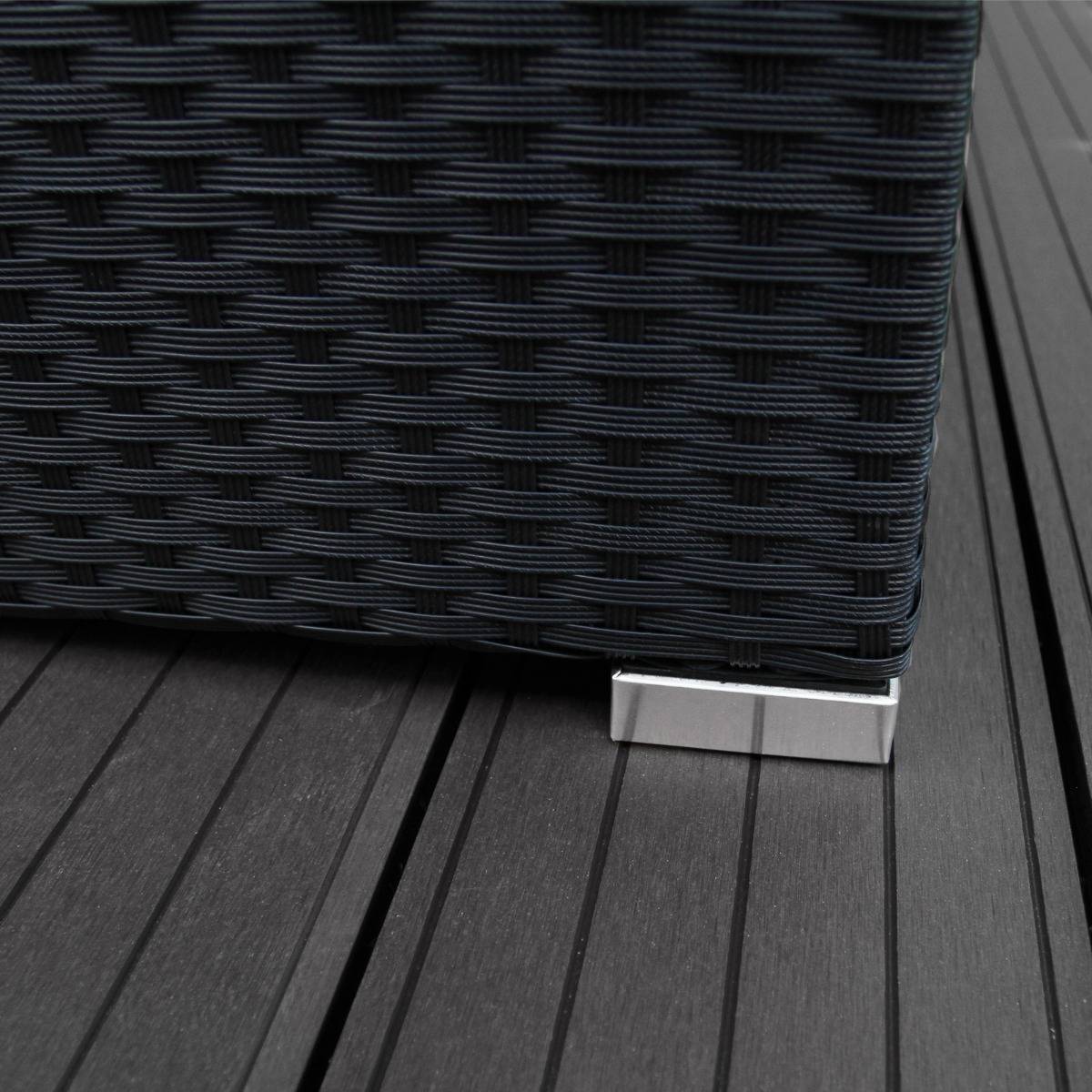 Set ad angolo in rattan nero con dettagli metallici, texture intrecciata e base elegante su pavimento in legno scuro