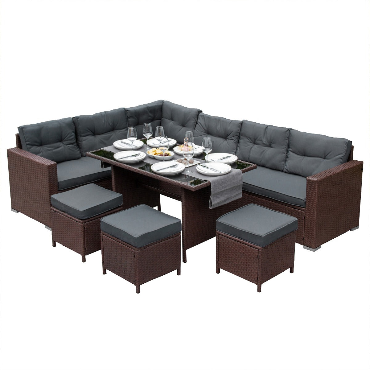 Set ad angolo in rattan marrone con cuscini grigi, tavolo centrale in vetro, ideale per esterni e momenti conviviali
