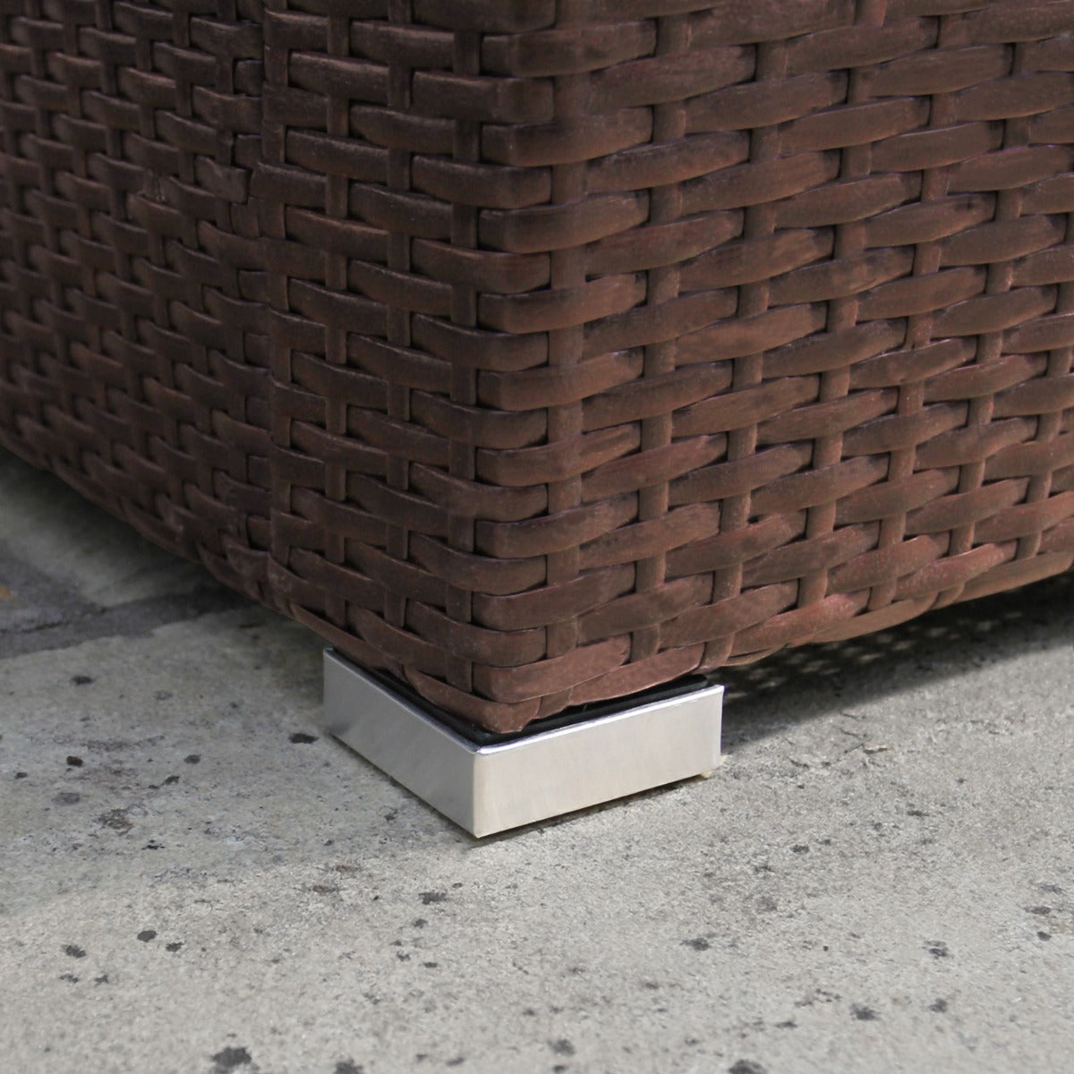 Set ad angolo in rattan marrone con dettagli metallici, texture intrecciata e base quadrata in metallo lucido per stabilità
