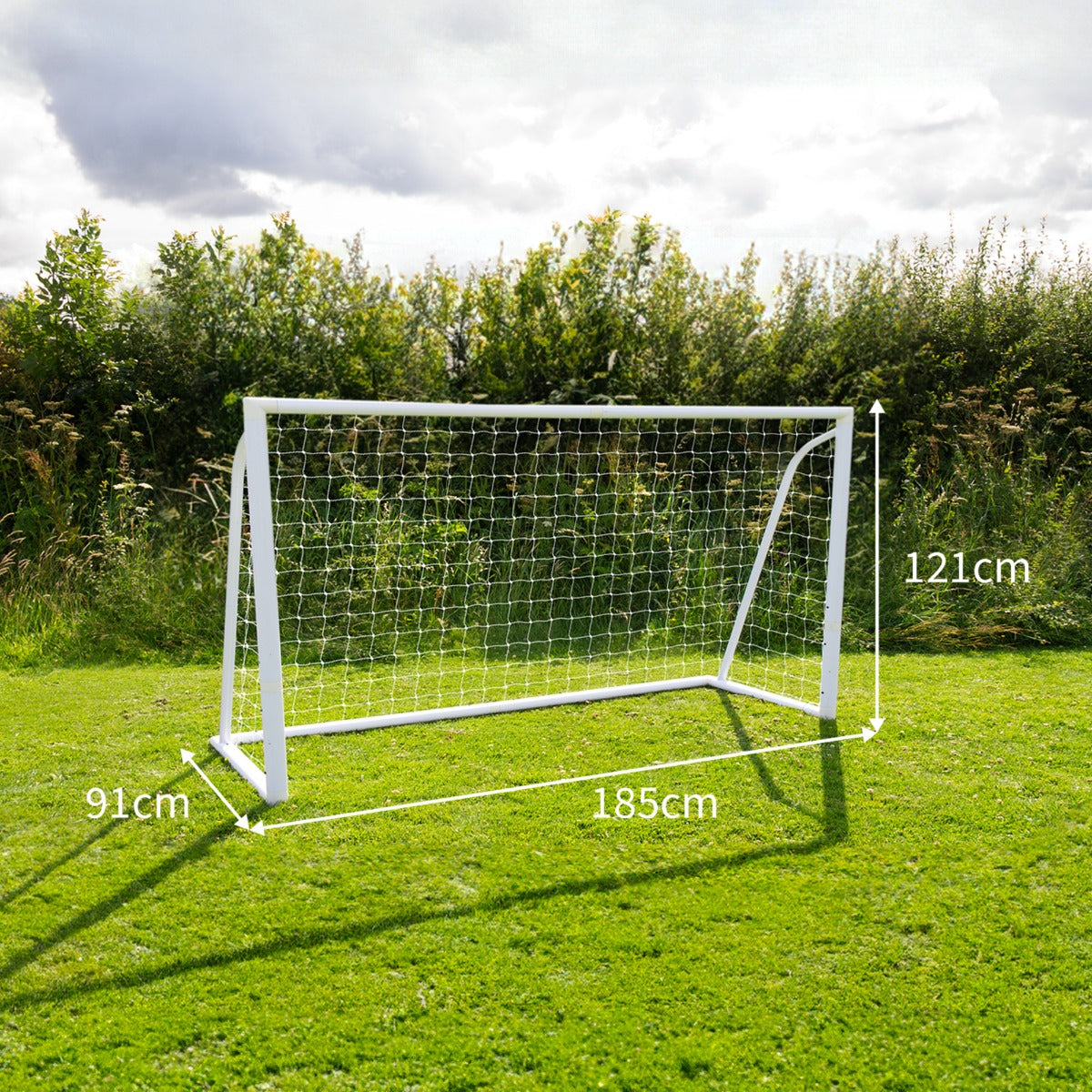 Porta da calcio bianca da 180cm x 120cm con rete, posizionata su un prato verde, circondata da alberi e cielo nuvoloso