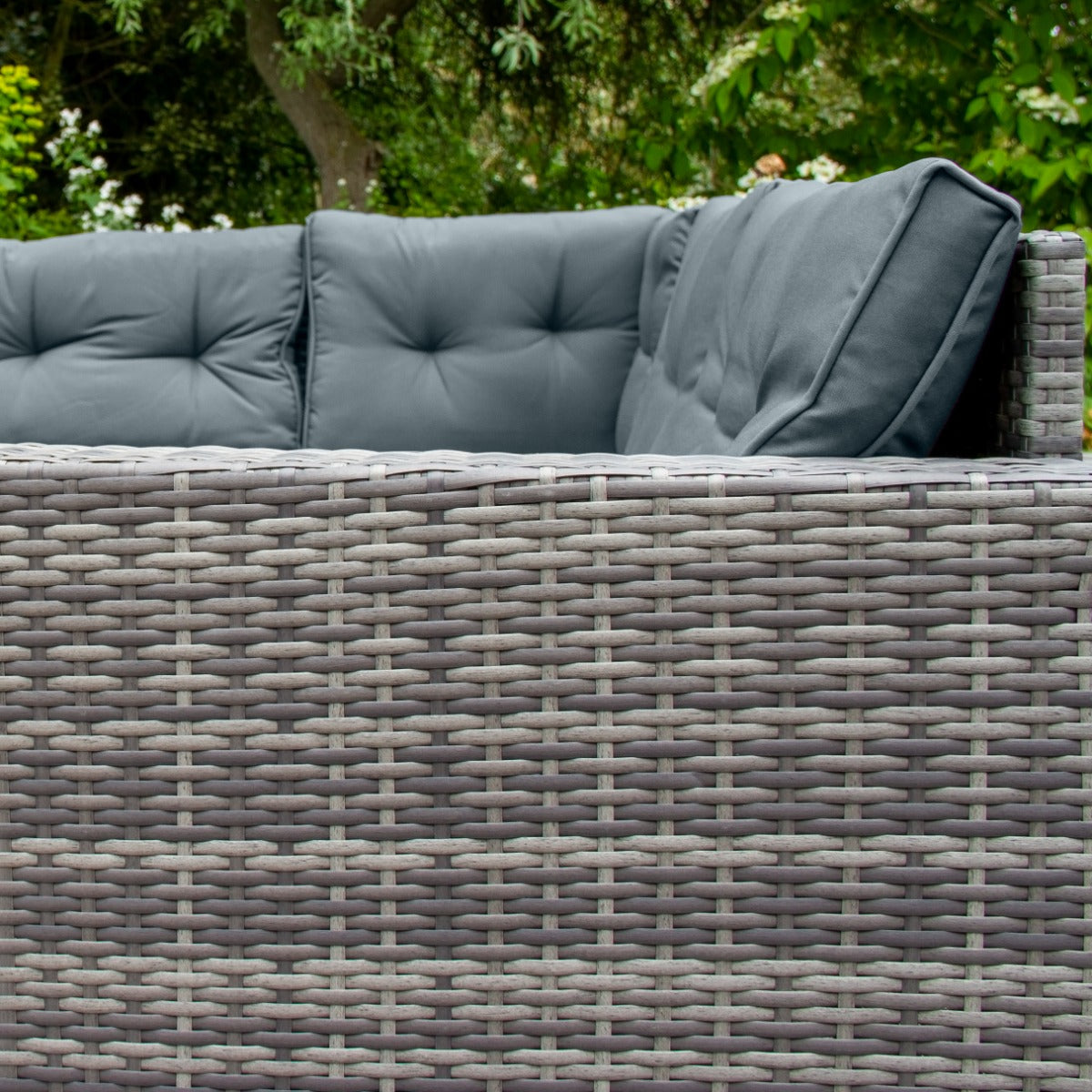 Set ad angolo in rattan grigio con cuscini morbidi, texture intrecciata e design elegante, ideale per spazi esterni e giardini