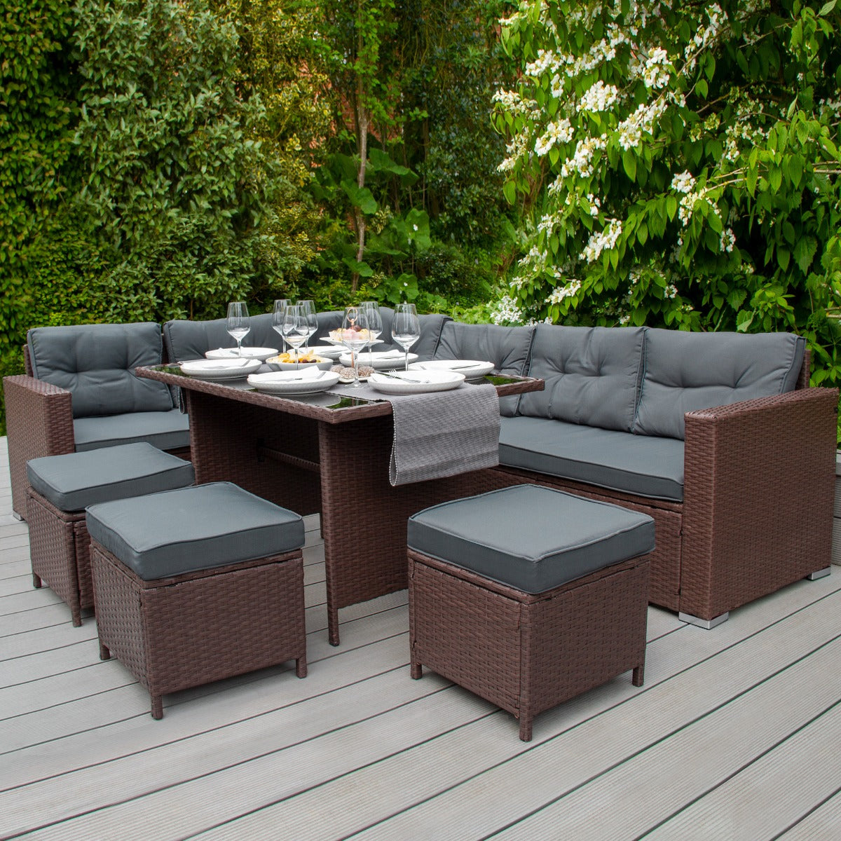 Set d'angolo in rattan marrone con cuscini grigi, tavolo centrale, sedie e box per riporre i cuscini, ideale per esterni