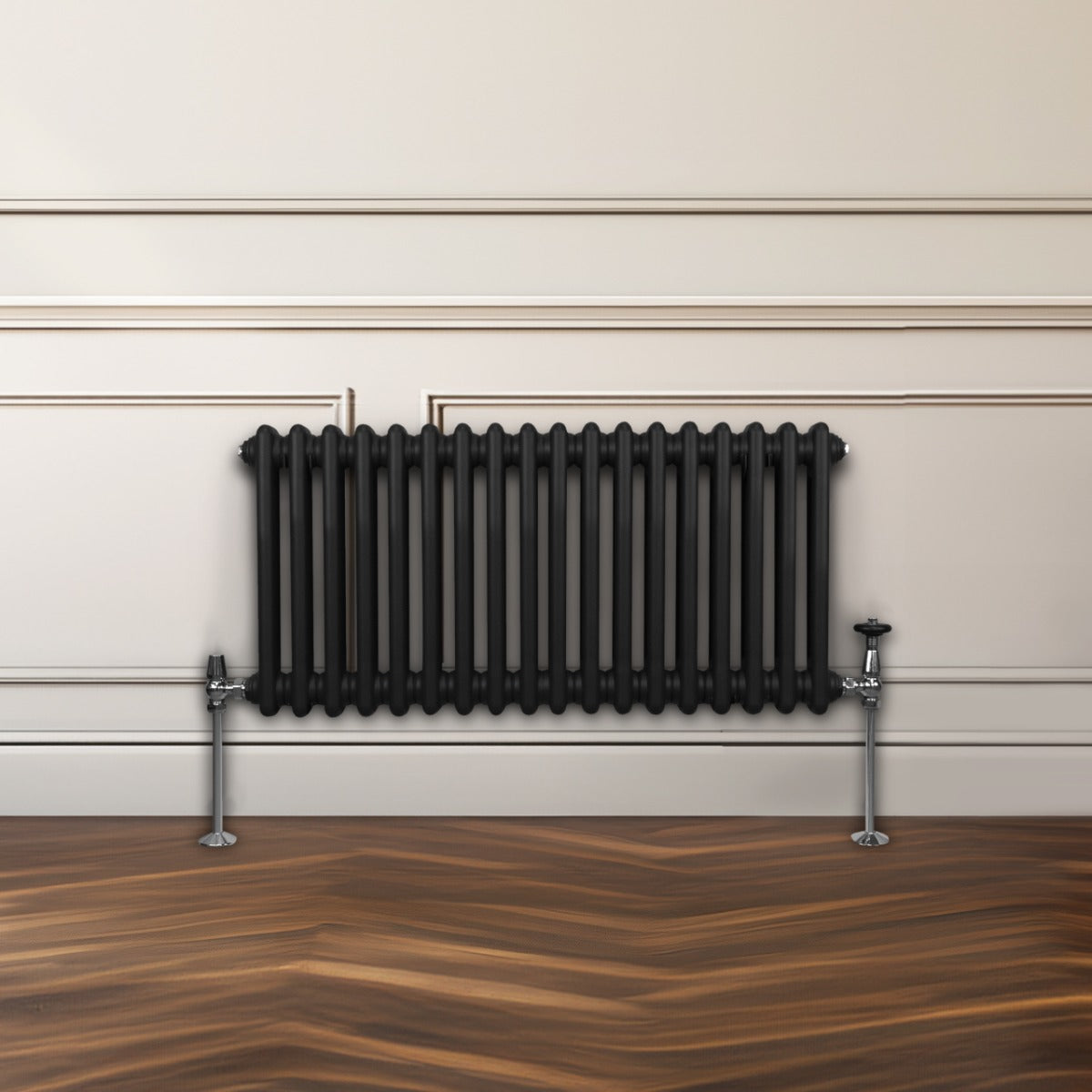 Termosifone a 2 colonne di colore nero, con finitura liscia e tubi rotondi, installato su una parete chiara, su pavimento in legno scuro