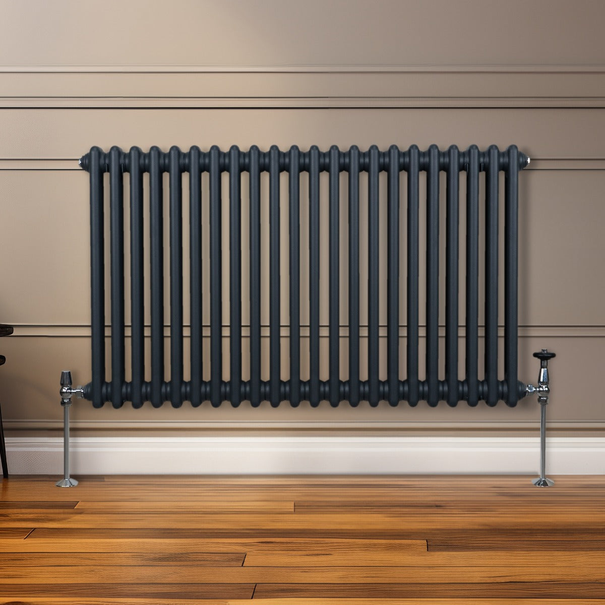 Termosifone a 2 colonne grigio antracite, con tubi verticali e supporti metallici, posizionato su una parete di legno chiaro