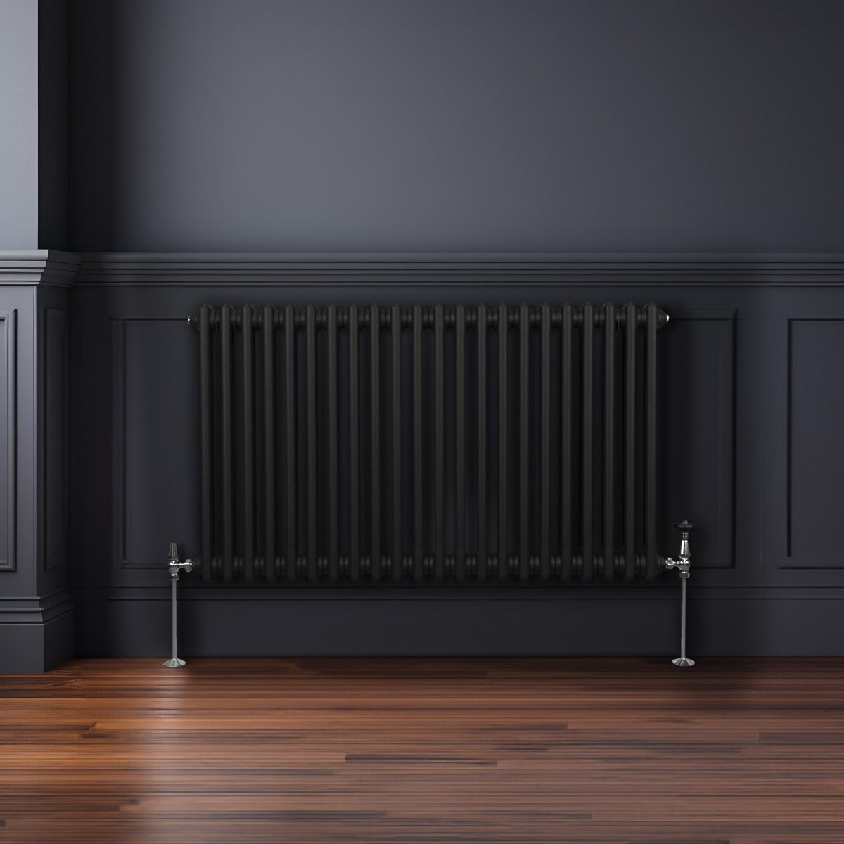 Termosifone a 2 colonne nero, 600 x 1012mm, con finitura liscia e tubi verticali, posizionato su un pavimento in legno scuro