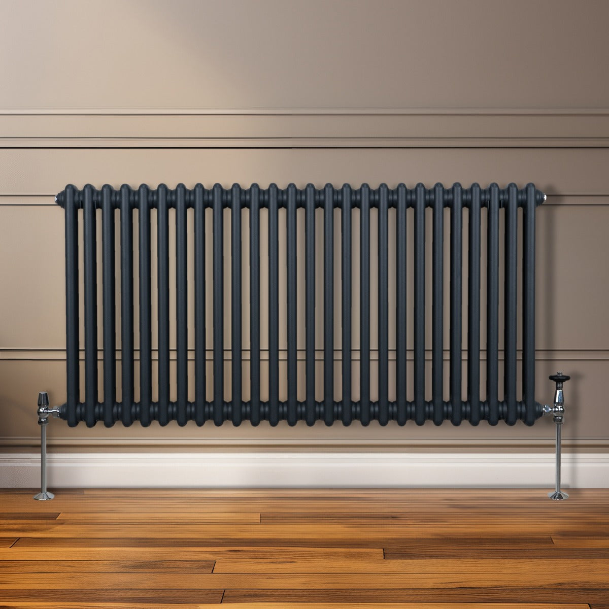 Termosifone a 2 colonne grigio antracite, con finitura liscia e tubi verticali, installato su parete con pavimento in legno chiaro
