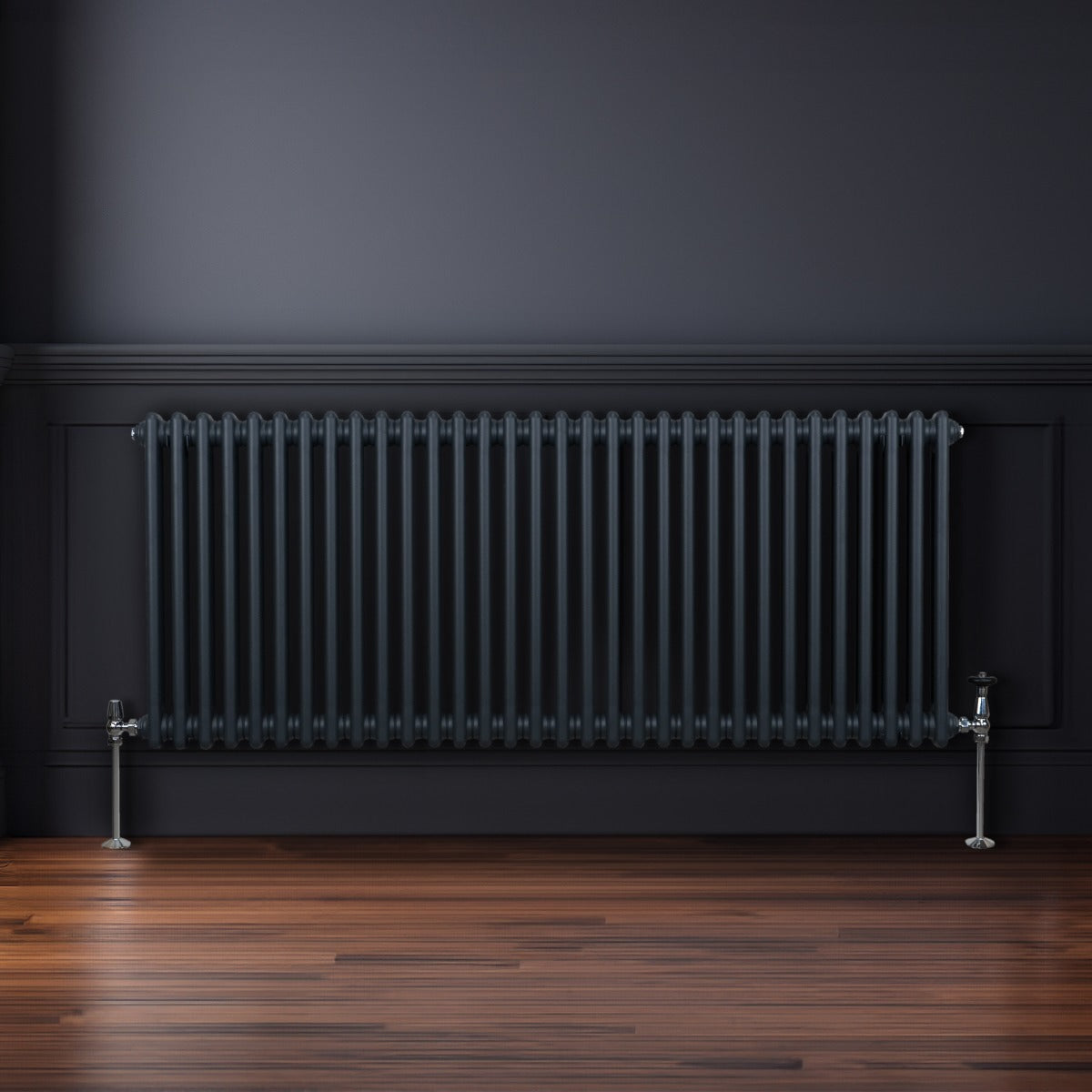 Termosifone a 2 colonne grigio antracite, con finitura liscia e tubi verticali, installato su parete in ambiente moderno con pavimento in legno