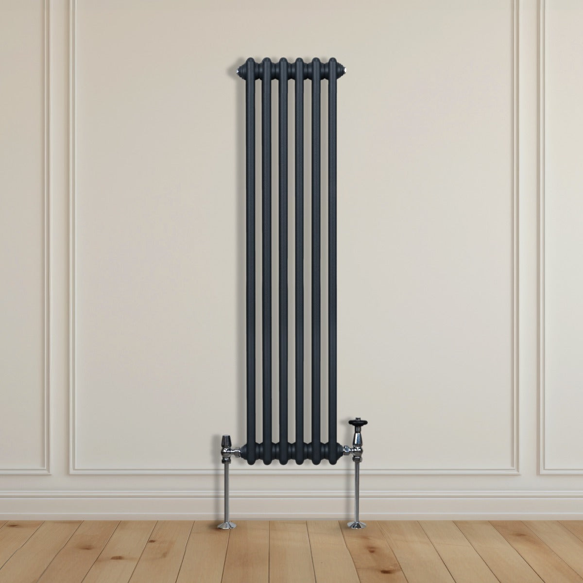 Termosifone a 2 colonne grigio antracite, alto e stretto, con tubi verticali e supporti metallici, installato su parete chiara