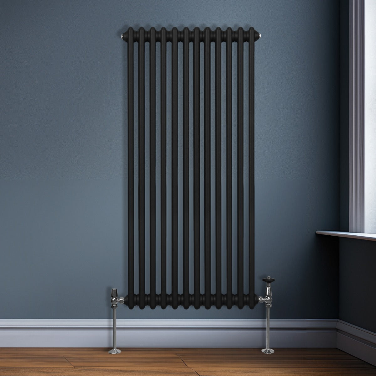 Termosifone a 2 colonne di colore nero, con finitura liscia, installato su una parete blu, con tubi metallici lucidi e pavimento in legno chiaro