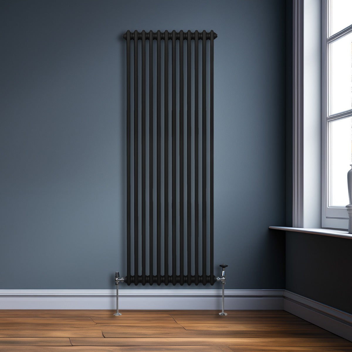Termosifone a 2 colonne nero, 1800 x 562mm, con finitura liscia e tubi verticali, installato su parete blu accanto a una finestra