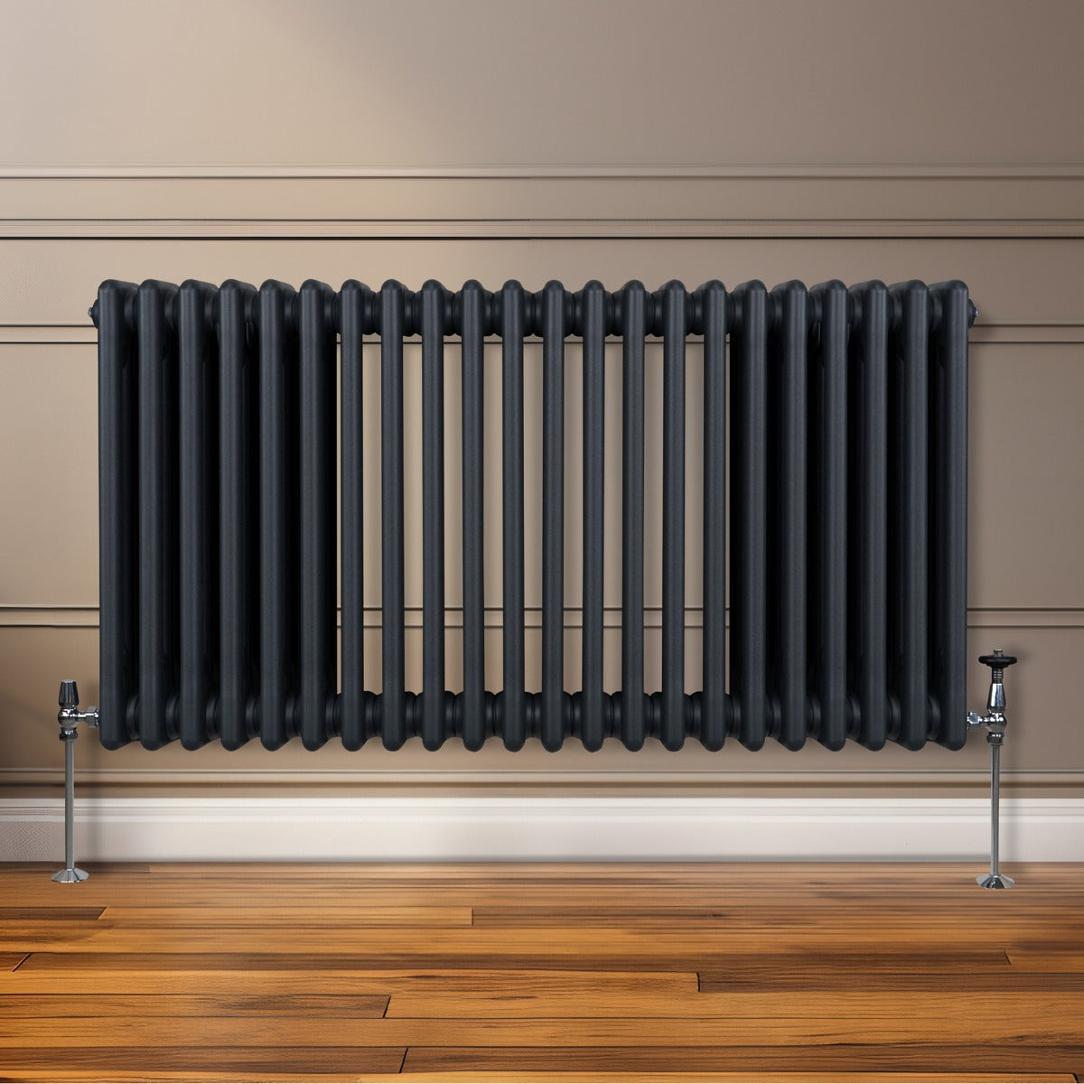 Termosifone a 3 colonne grigio antracite, con finitura liscia e tubi verticali, installato su parete in legno chiaro