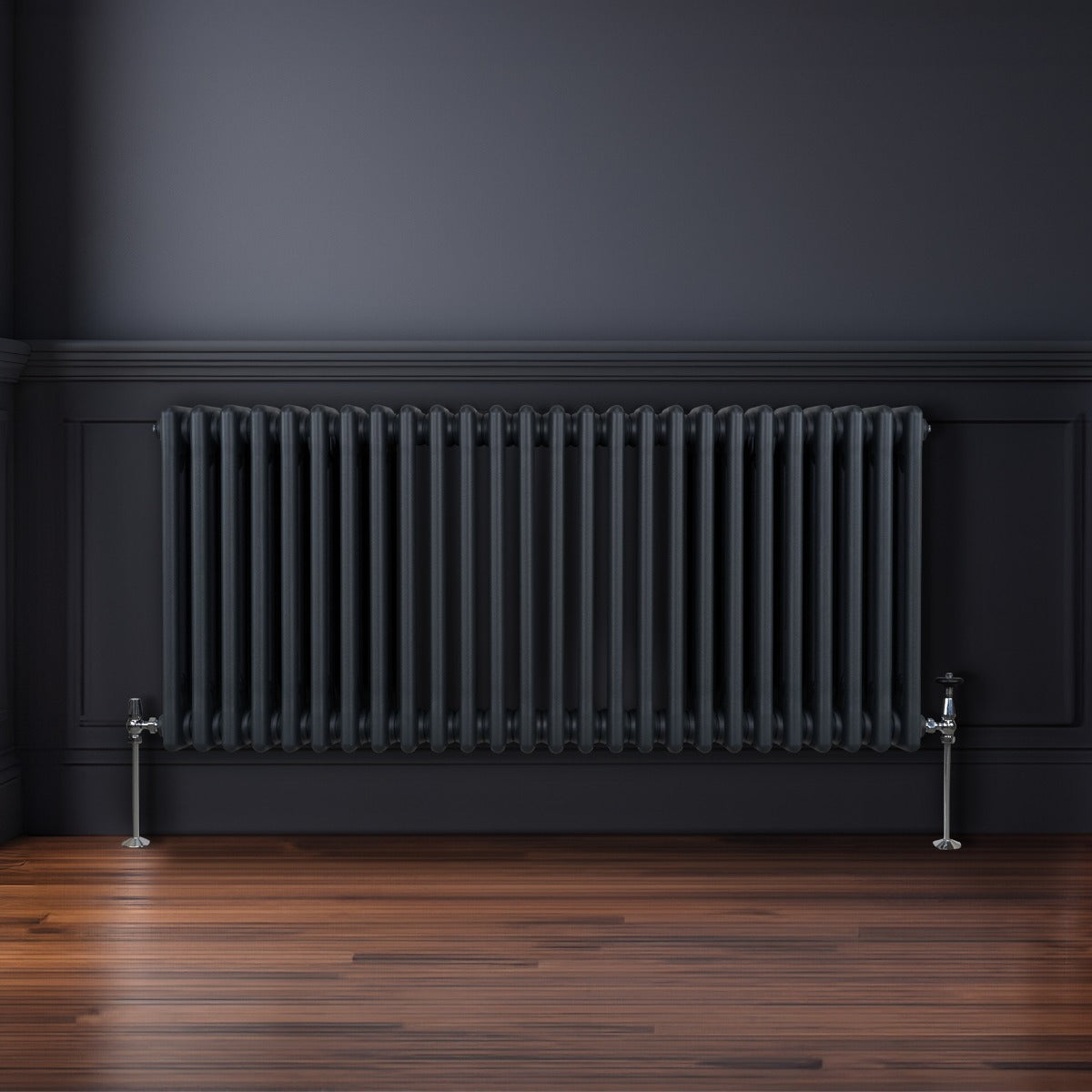 Termosifone a 3 colonne grigio antracite, con finitura liscia e tubi verticali, installato su parete scura in un ambiente elegante