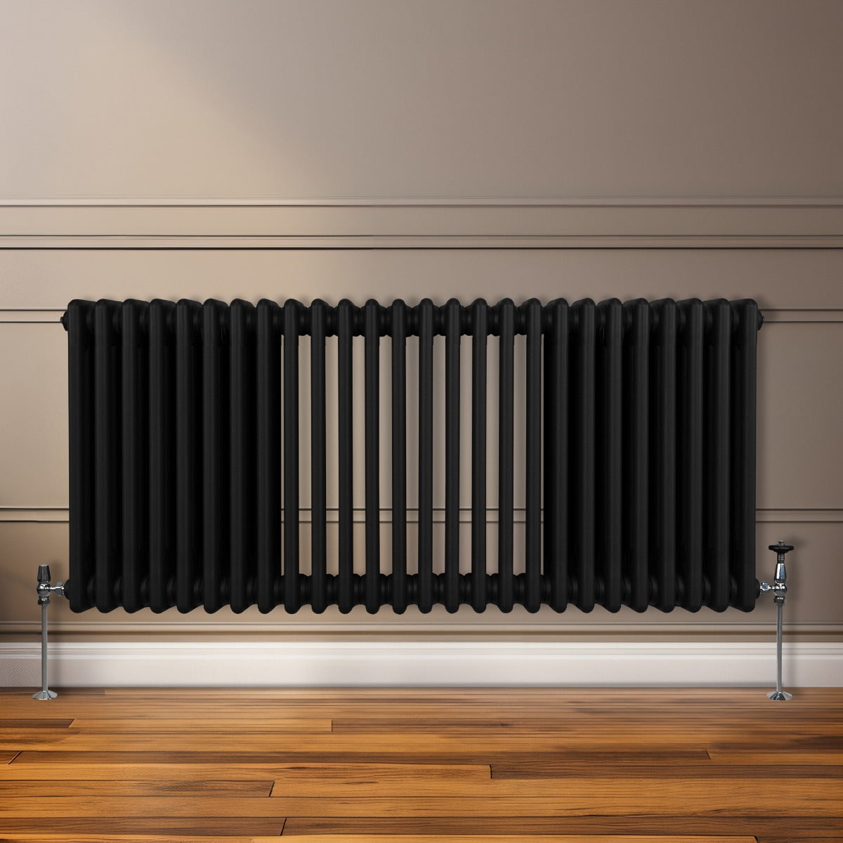 Termosifone a 3 colonne di colore nero, 600 x 1192mm, con finitura liscia e tubi verticali, installato su parete chiara con pavimento in legno