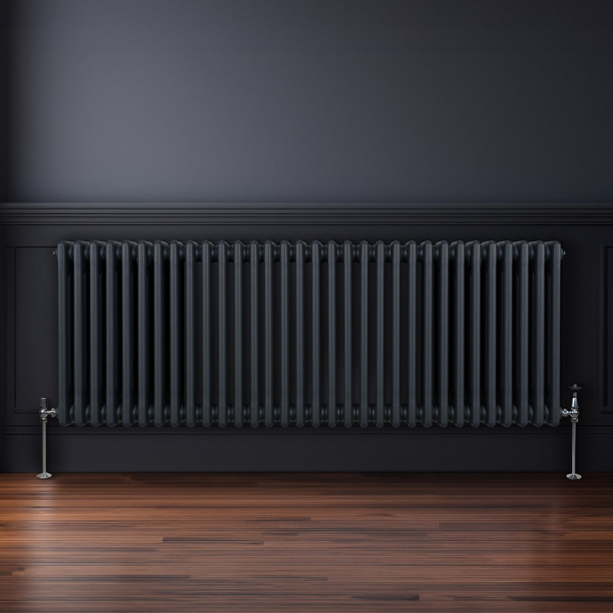 Termosifone a 3 colonne grigio antracite, con finitura liscia e lucida, installato su parete scura, su pavimento in legno lucido