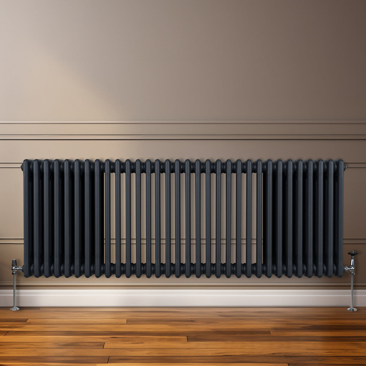 Termosifone a 3 colonne grigio antracite, con finitura liscia e linee eleganti, posizionato su parete beige accanto a pavimento in legno