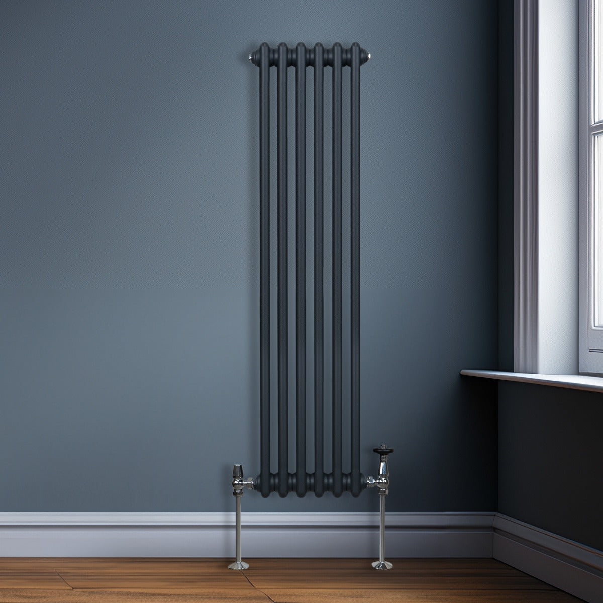 Termosifone a 3 colonne grigio antracite, elegante e moderno, installato su parete blu, con tubi metallici lucidi e finitura liscia