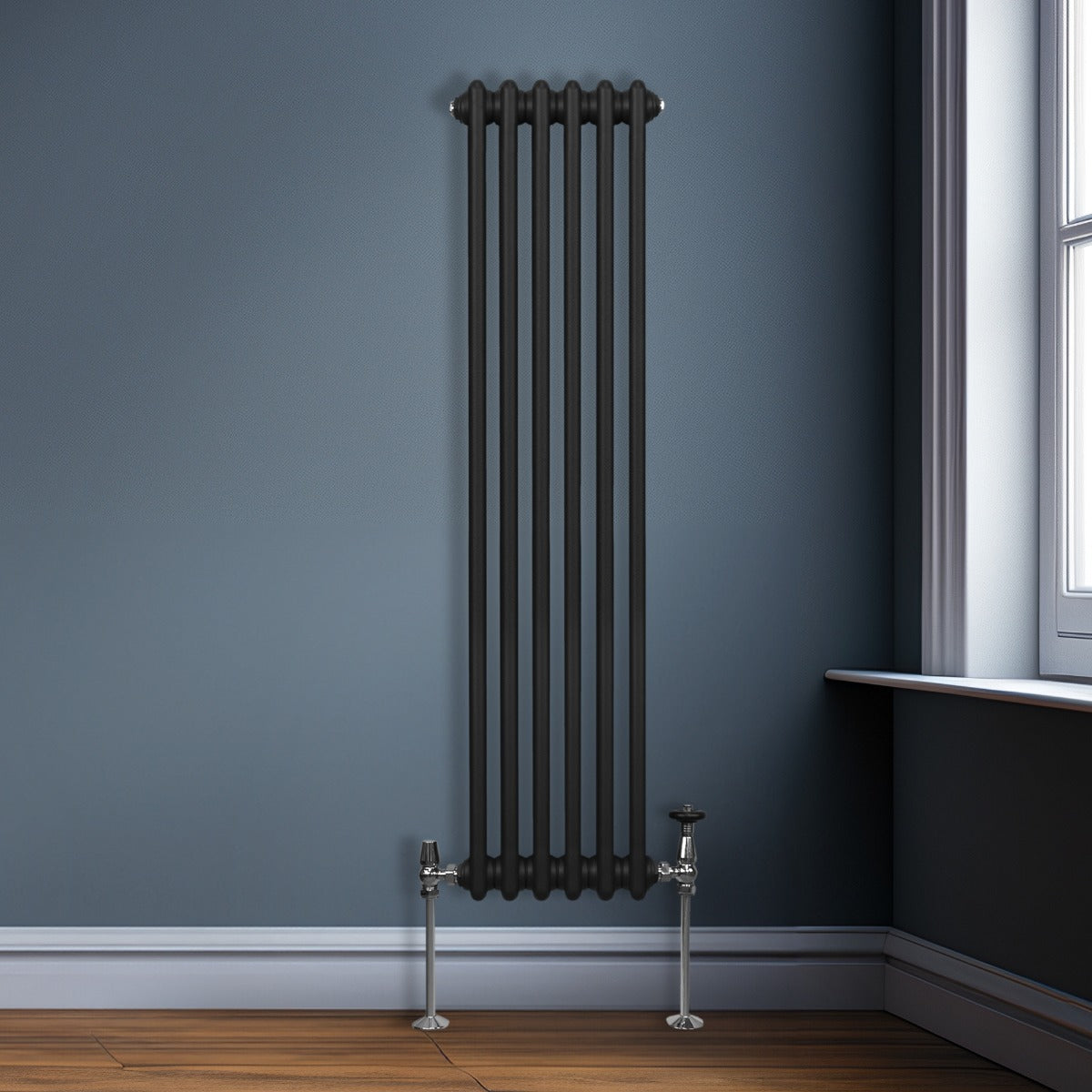 Termosifone a 3 colonne nero, 1500 x 292mm, con finitura liscia e tubi rotondi, installato su parete grigia, accanto a un pavimento in legno scuro