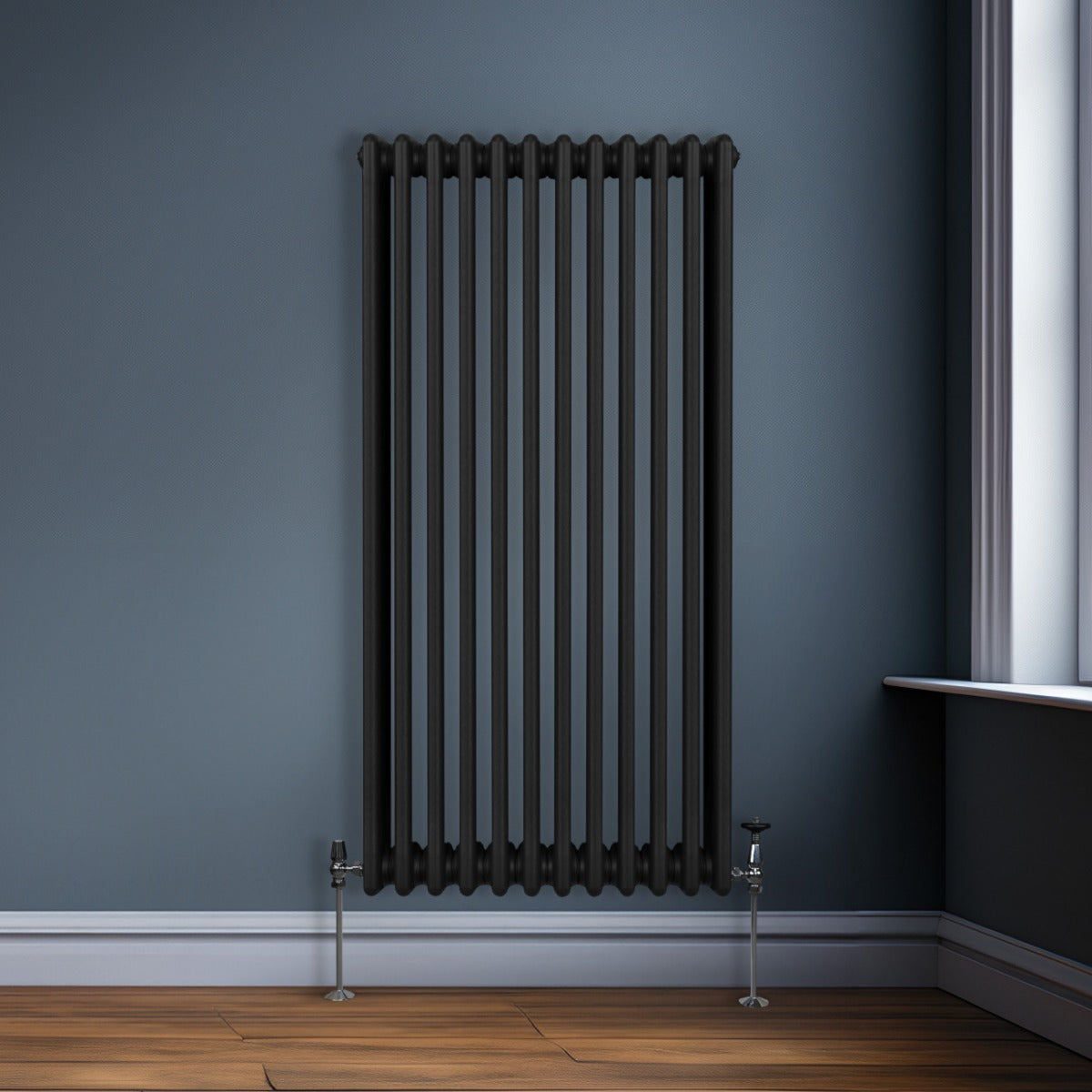 Termosifone a 3 colonne di colore nero, 1500 x 562mm, con finitura liscia e tubi verticali, installato in un ambiente moderno con pareti blu