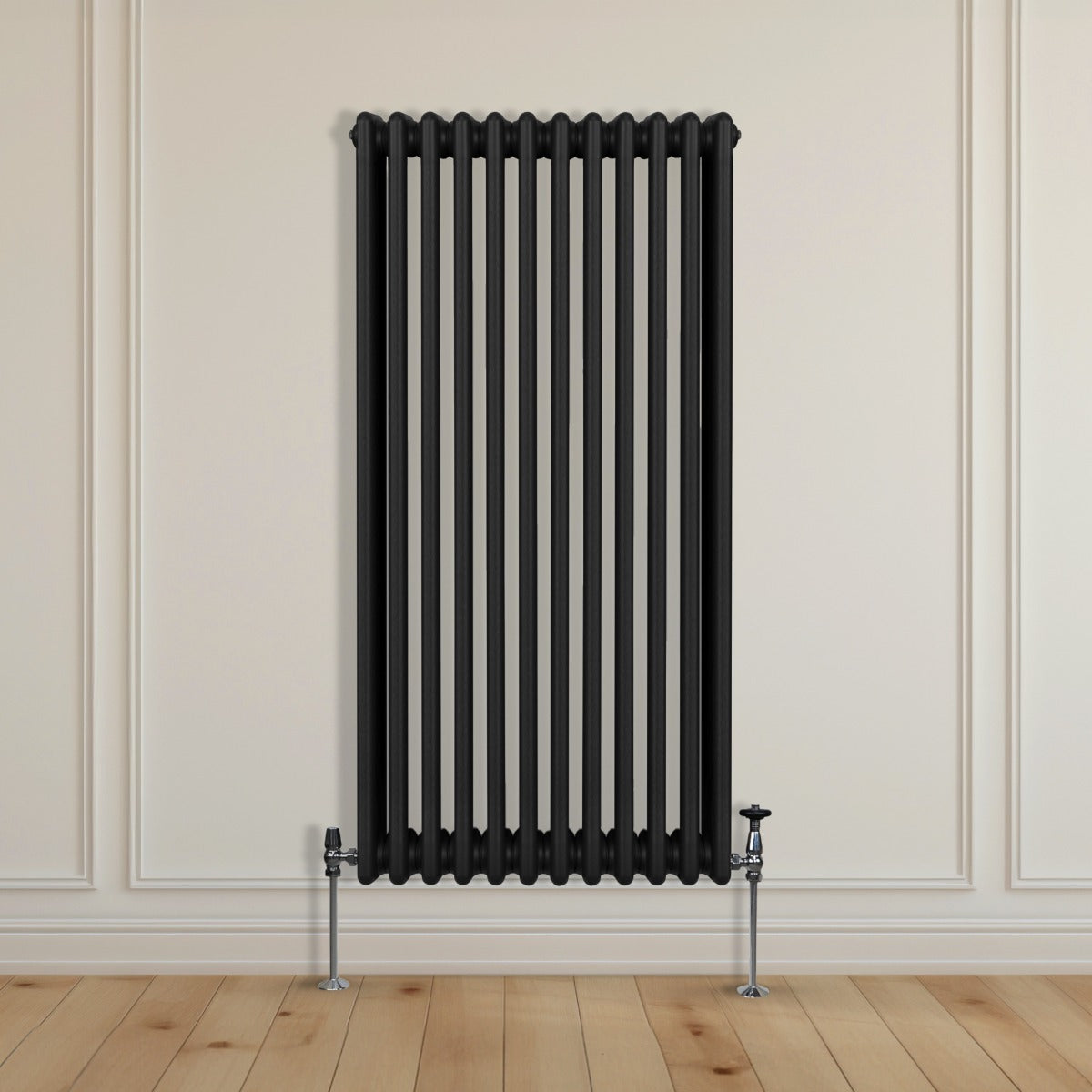 Termosifone a 3 colonne nero, 1500 x 562mm, con finitura liscia e tubi verticali, installato su parete chiara con pavimento in legno