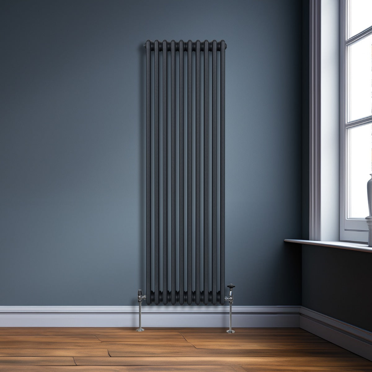 Termosifone a 3 colonne grigio antracite, elegante e moderno, installato su parete blu, con finitura liscia e dettagli metallici lucidi