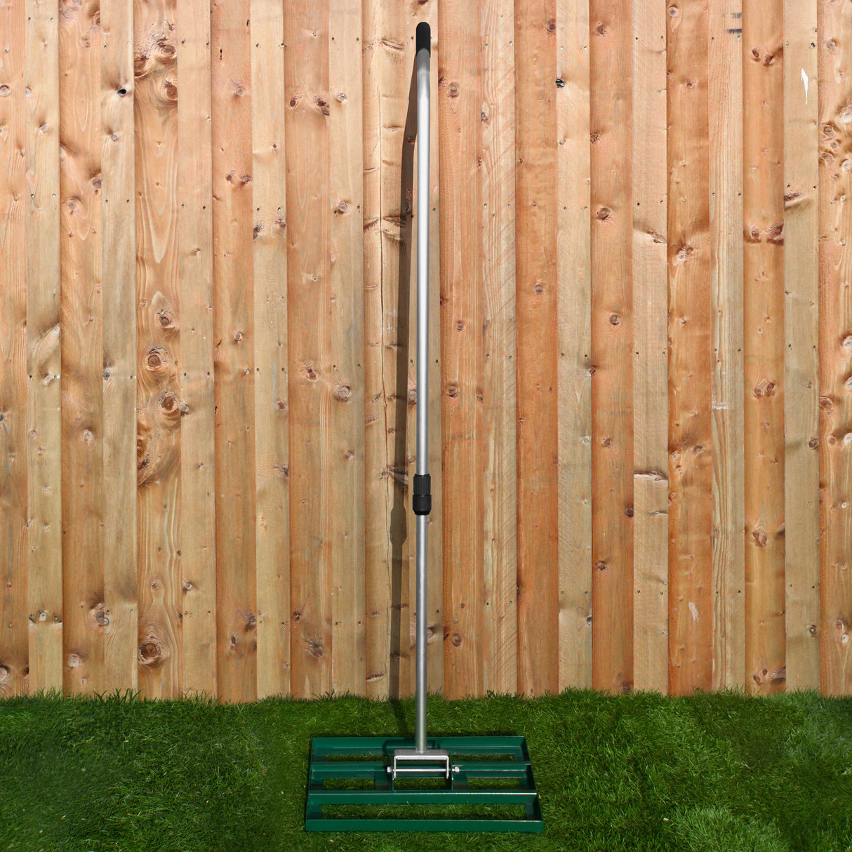 Set arieggiatore e livellatore prato da 50 cm, struttura in metallo argentato, base verde, posizionato su erba verde con sfondo di legno naturale