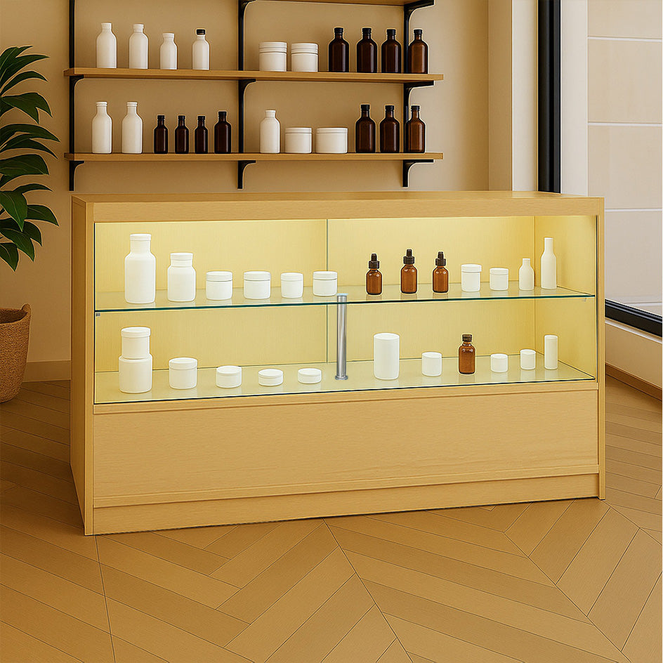 Bancone da negozio in legno d'acero con illuminazione LED, ripiani in vetro e prodotti cosmetici in contenitori bianchi e marroni