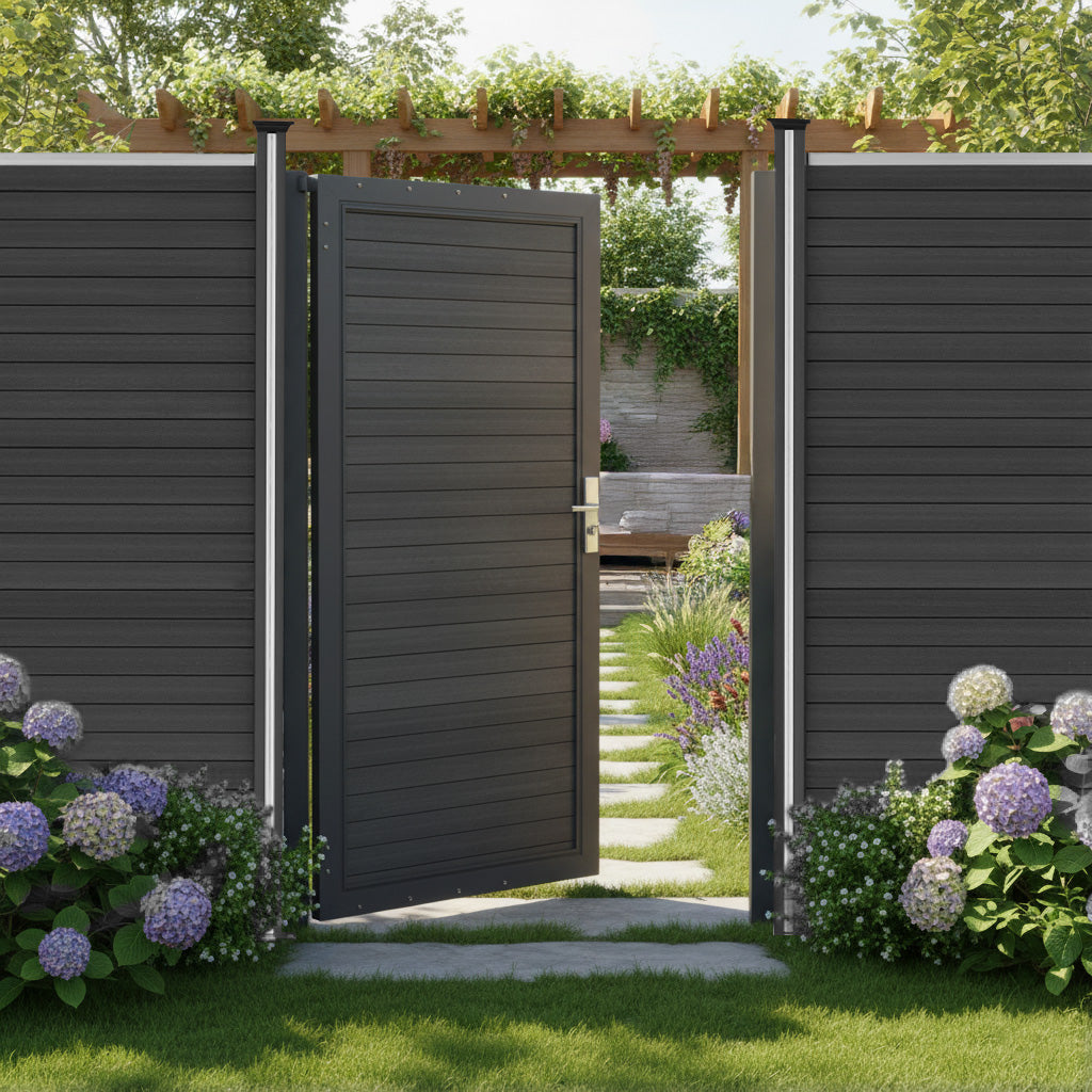 Porta da giardino in pannello ecolegno grigio, con finitura liscia, circondata da fiori colorati e un sentiero di pietra nel giardino