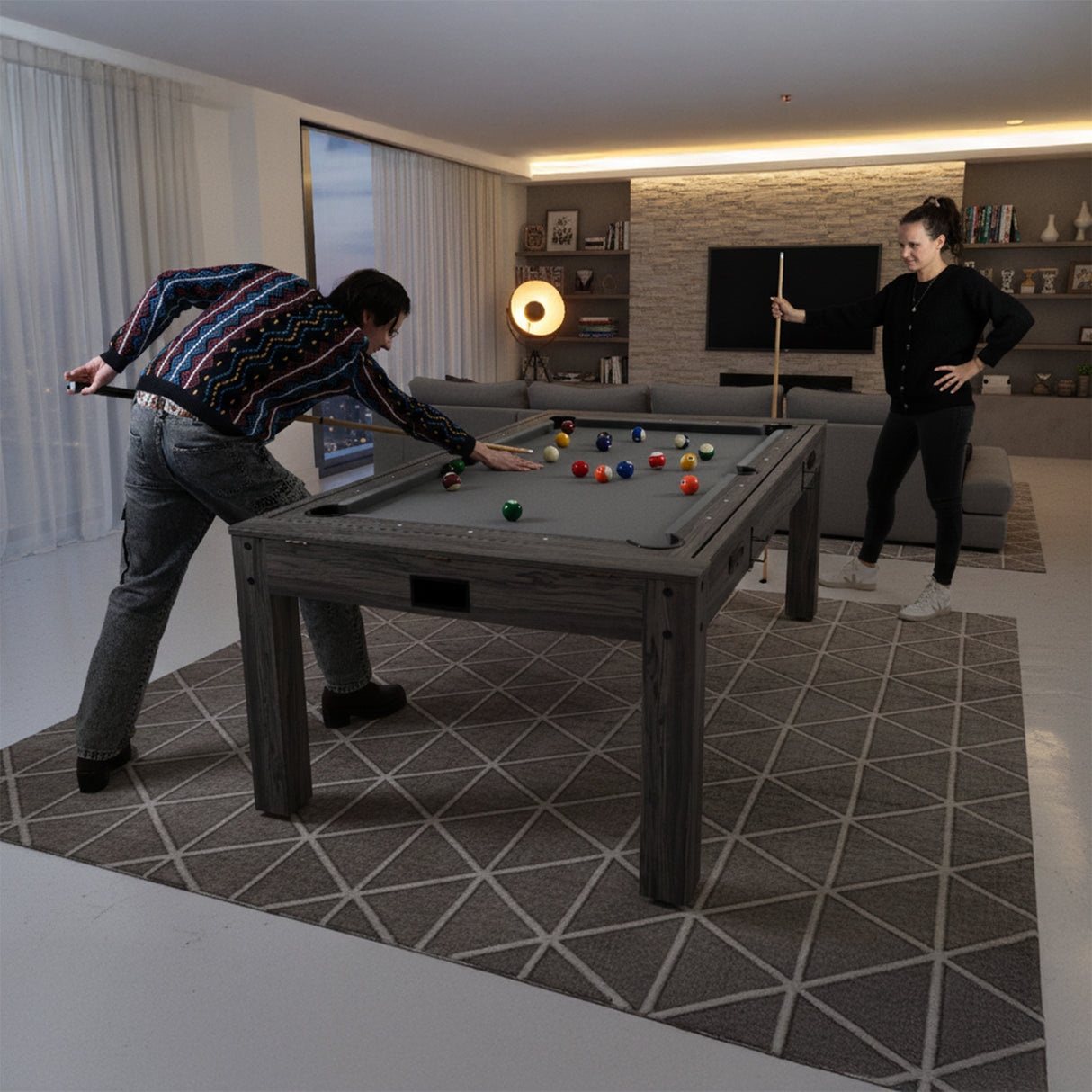 Tavolo multigioco 7-in-1 effetto legno grigio, con superficie grigia, utilizzato da due persone per giochi come biliardo e ping pong
