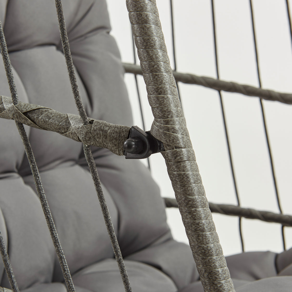 Poltrona sospesa a uovo in rattan grigio con struttura robusta, cuscini morbidi e dettagli intrecciati in corda resistente