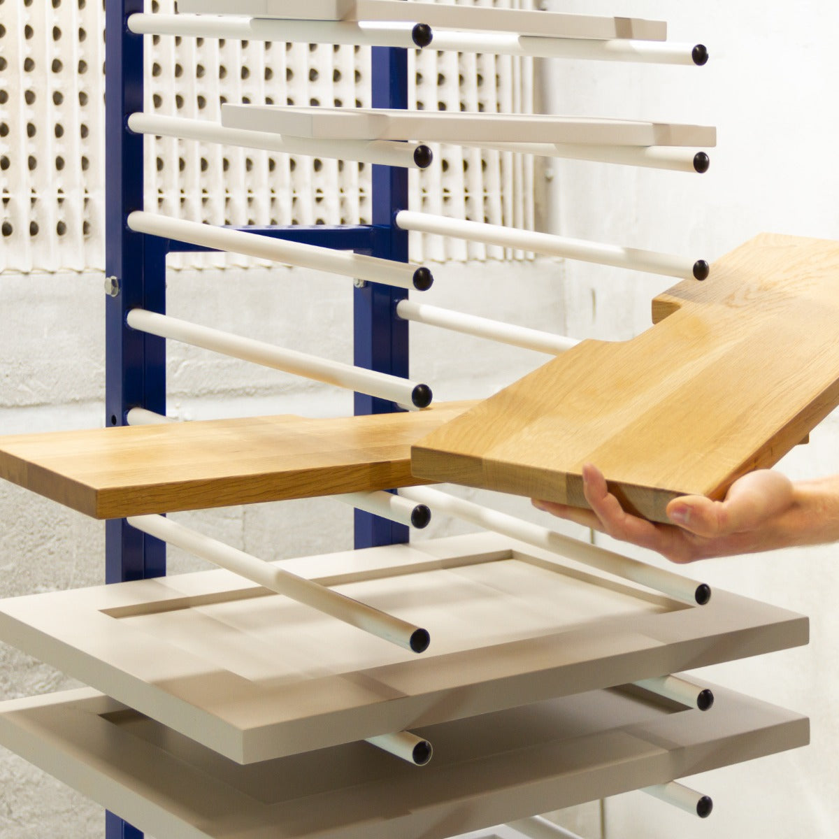 Rastrelliera per essiccazione vernice con ripiani in legno chiaro e struttura metallica blu, ideale per organizzare materiali verniciati