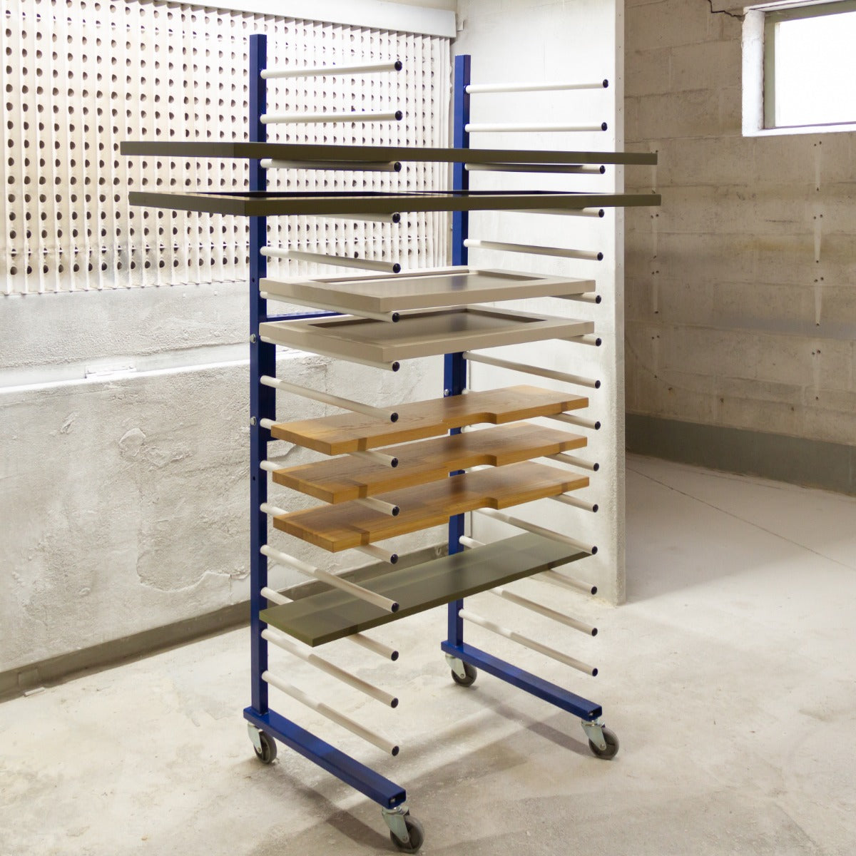 Rastrelliera per essiccazione vernice con struttura blu, ripiani in legno e vetro, ruote per facile spostamento in laboratorio