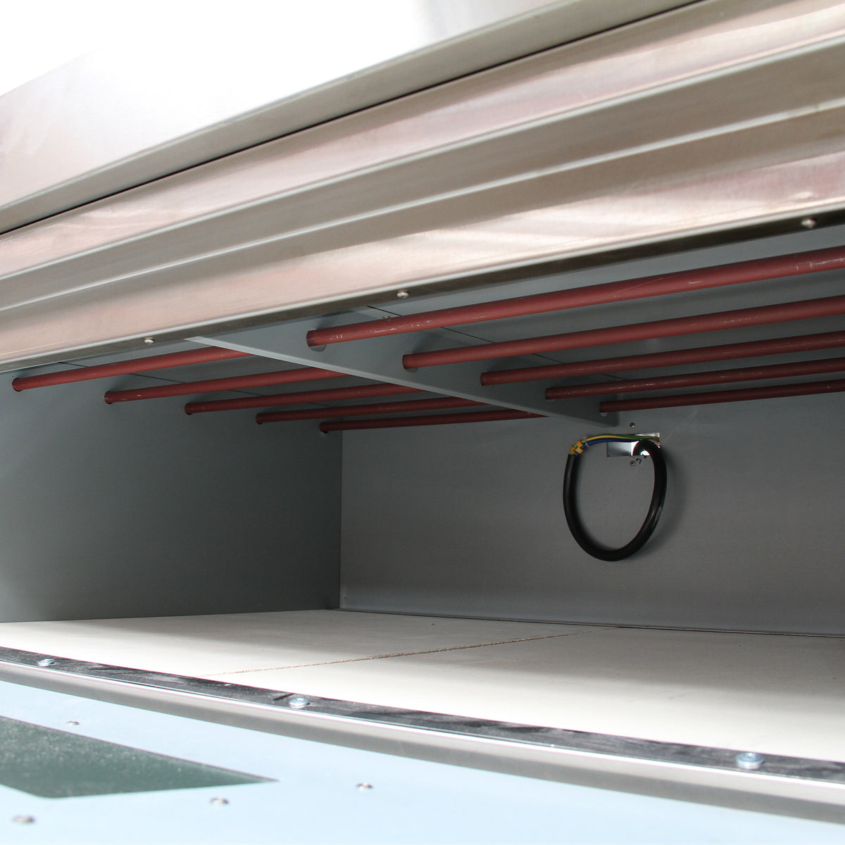 Interno del forno a convezione KuKoo da 60 cm, con ripiani metallici rossi e superficie grigia, progettato per una cottura uniforme