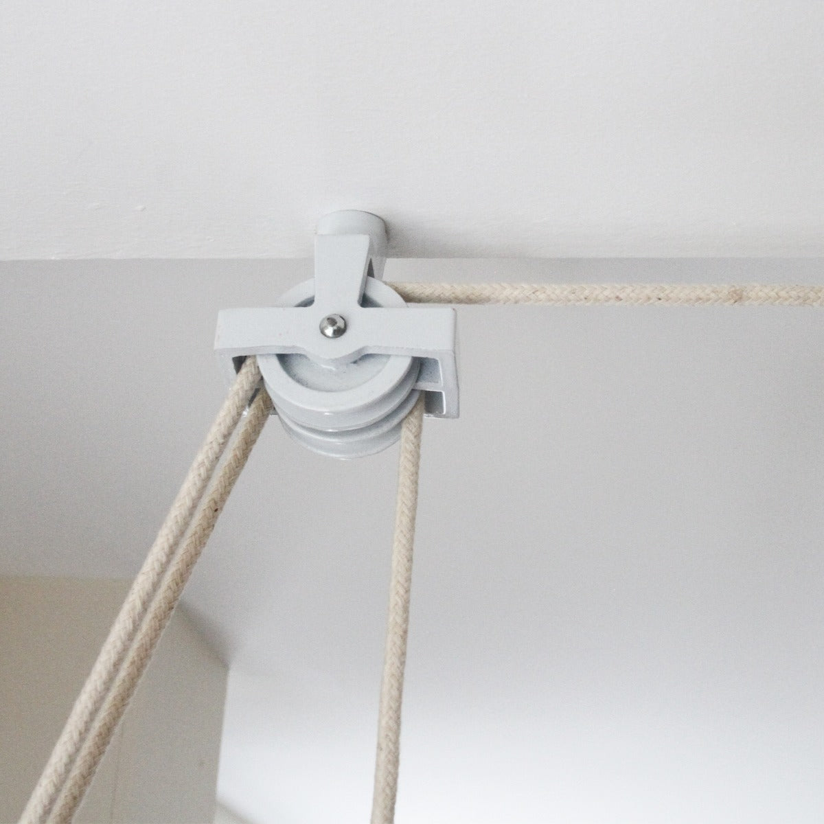 Stendibiancheria da soffitto bianco con puleggia grigia e corde beige, ideale per ottimizzare lo spazio e asciugare i vestiti
