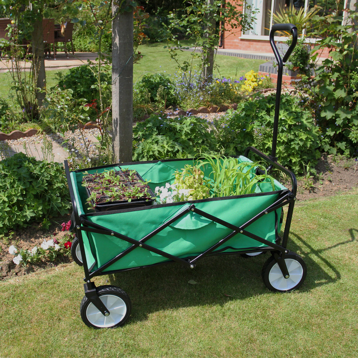 Carrello da giardino pieghevole verde con struttura nera, ruote bianche, ideale per trasportare piante e attrezzi da giardinaggio