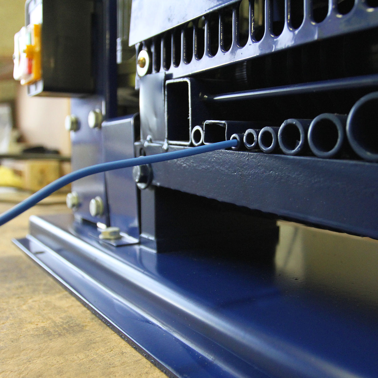 Spella cavi automatica T-Mech 38mm, struttura metallica blu, dettagli in plastica nera, cavi e tubi in evidenza, design robusto e funzionale