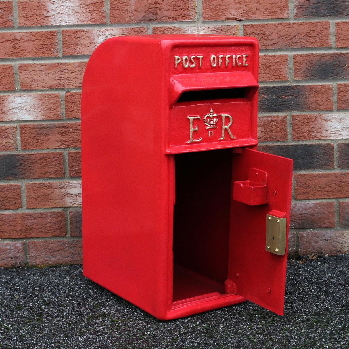 Cassetta postale britannica rossa con piedistallo, decorata con la scritta "POST OFFICE" e il monogramma "ER", porta aperta