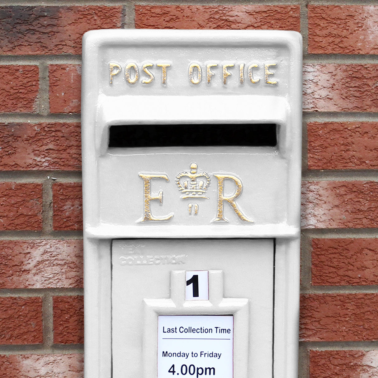 Cassetta postale britannica bianca con dettagli dorati, logo E.R., e orario di raccolta affisso sulla parte anteriore