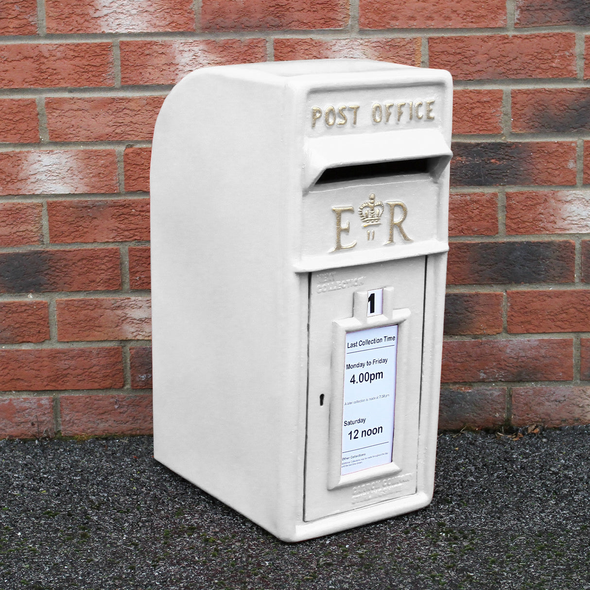 Cassetta postale britannica bianca con dettagli in rilievo, scritta "POST OFFICE" e orari di raccolta ben visibili