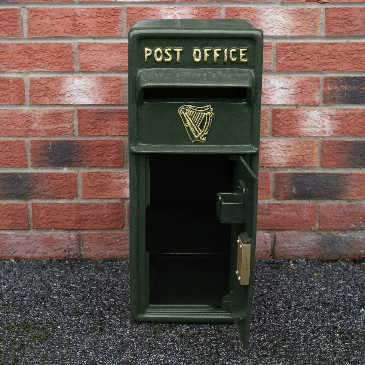 Cassetta postale britannica verde con piedistallo, decorata con scritta dorata "POST OFFICE" e simbolo dell'arpa, apertura frontale