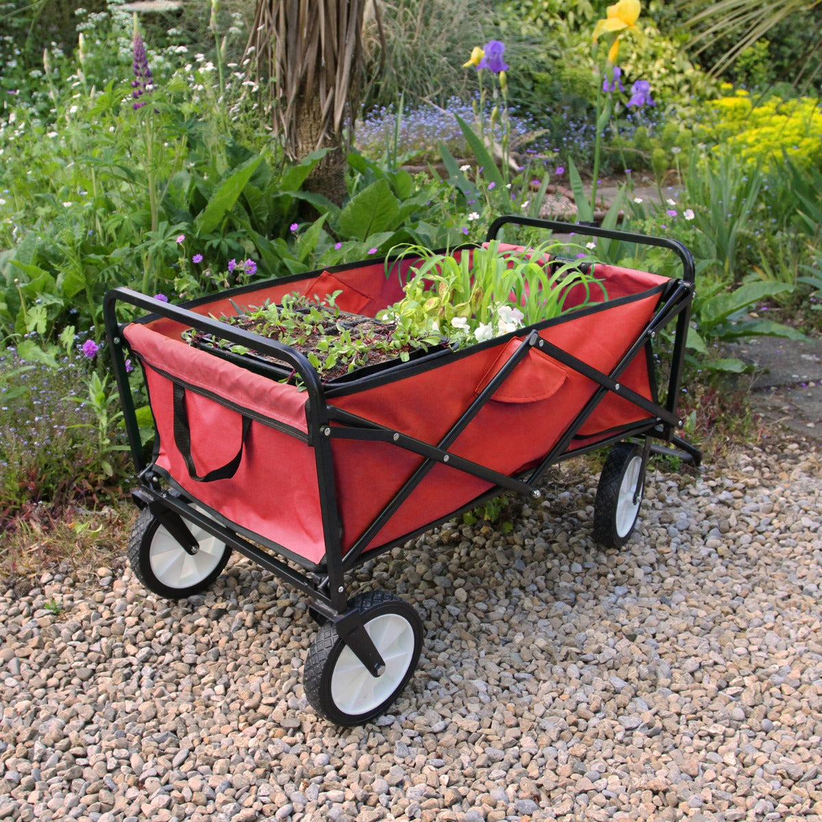 Carrello da giardinaggio pieghevole rosso con struttura nera, ruote bianche e tasche laterali, ideale per trasportare piante e attrezzi
