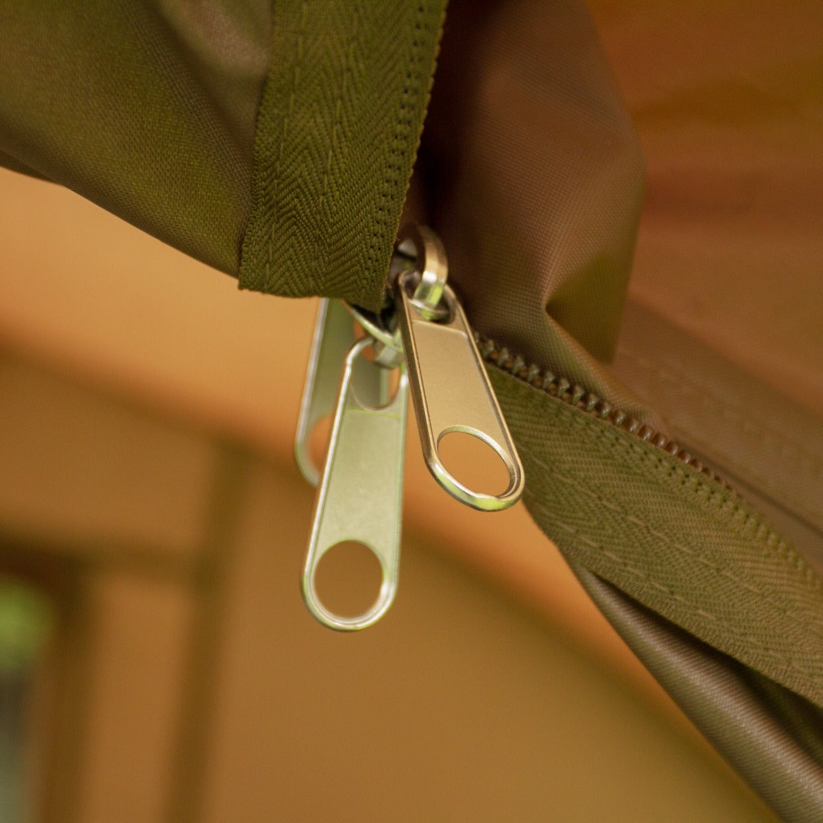 Cerniera della tenda bivvy da pesca, con dettagli metallici lucidi su tessuto verde oliva resistente, ideale per due persone
