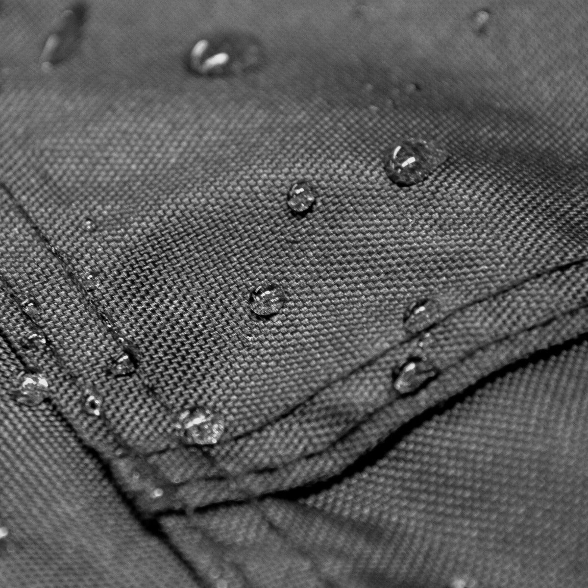 Tessuto nero della tenda per motociclette con gocce d'acqua, evidenziando la sua resistenza all'acqua e la texture robusta