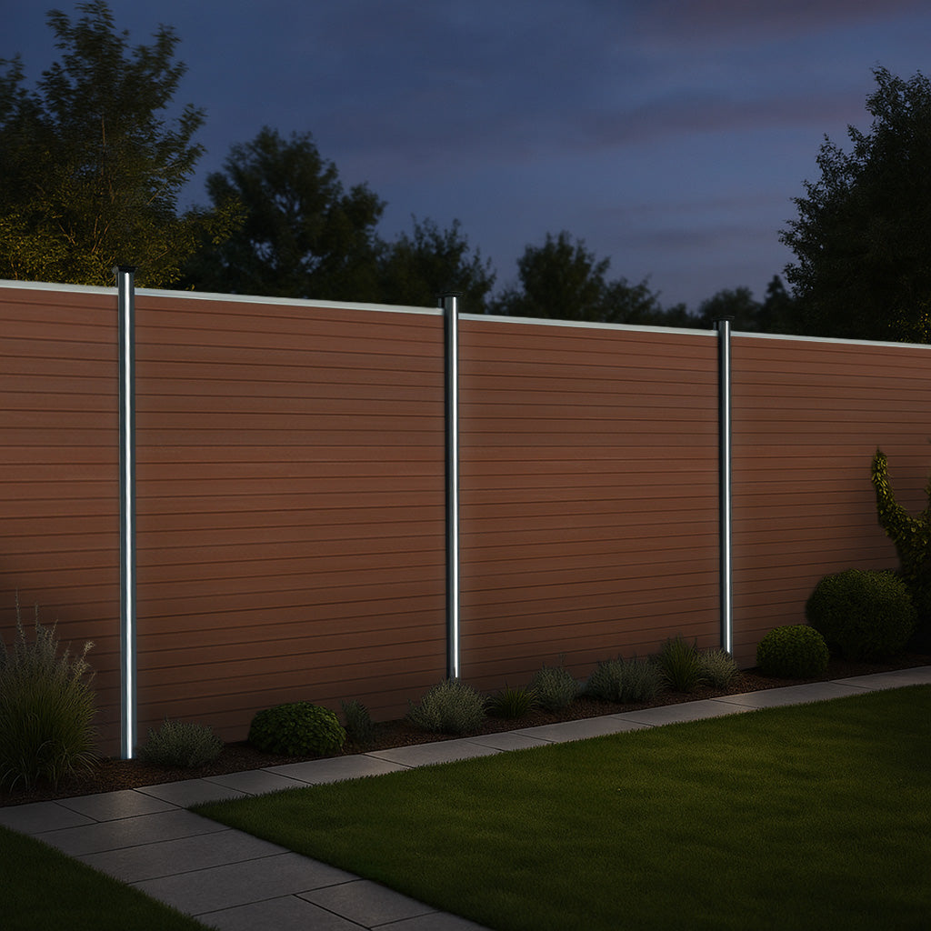 Pannelli di recinzione marroni in alluminio con pali LED, illuminazione elegante in un giardino verde al crepuscolo