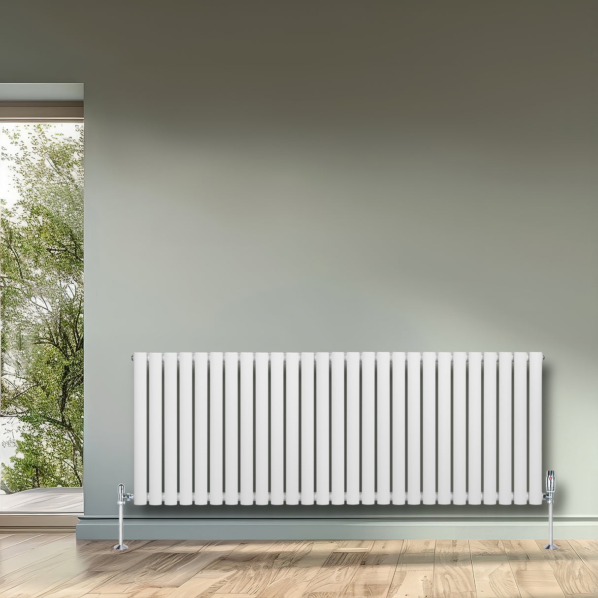 Radiatore ovale a colonna singola orizzontale bianco, con finitura liscia e valvole, posizionato su parete verde chiaro in ambiente luminoso